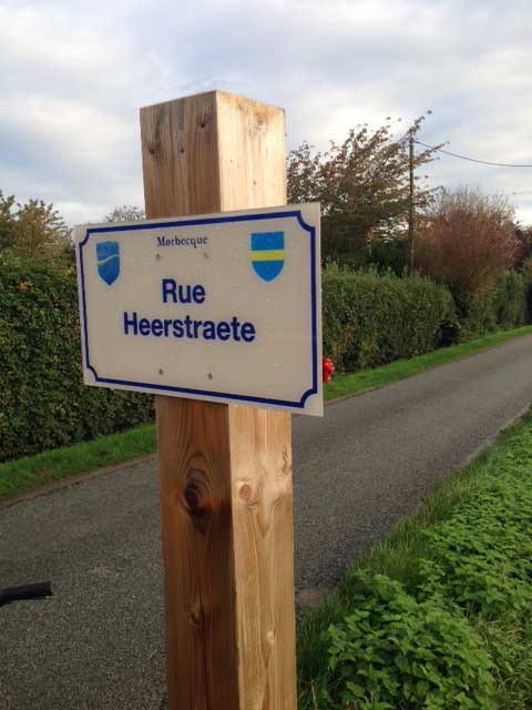 Photo d'un panneau de rue personnalisé fixé sur un poteau en bois