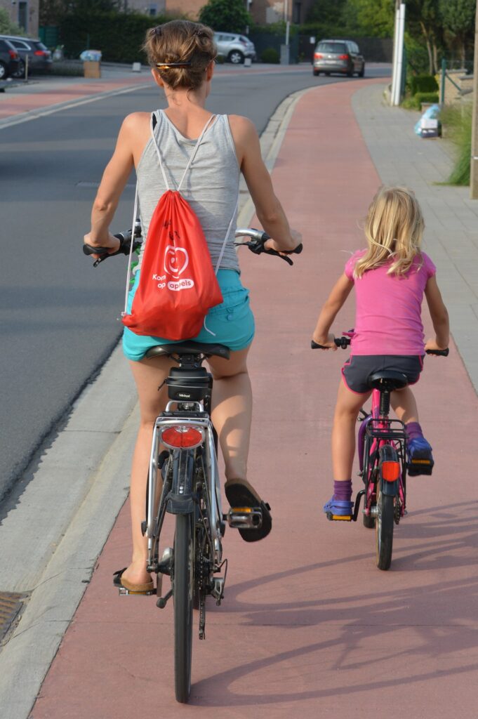 Photo d'une femme et une petite fille sur leur vélo sur une piste cyclable